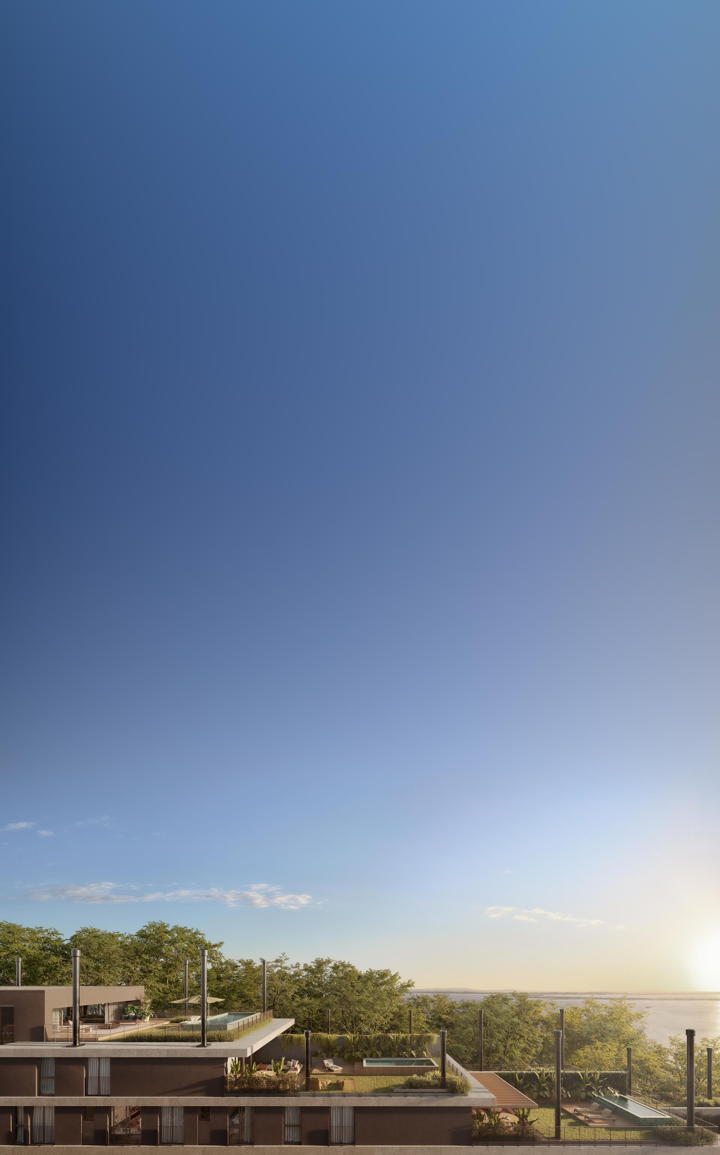 Céu em degradê do azul ao rosado sobre as casas do Altana, entre a vegetação, com o Guaíba ao fundo